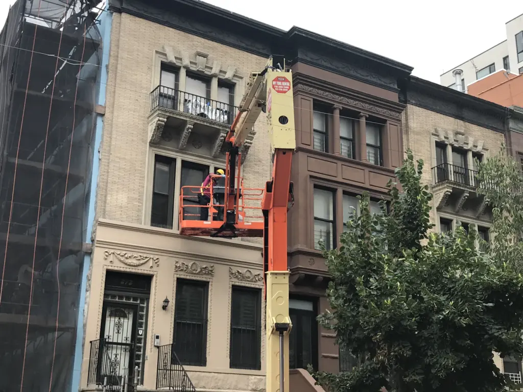 Boom lift used for bird control installation on a Manhattan building exterior