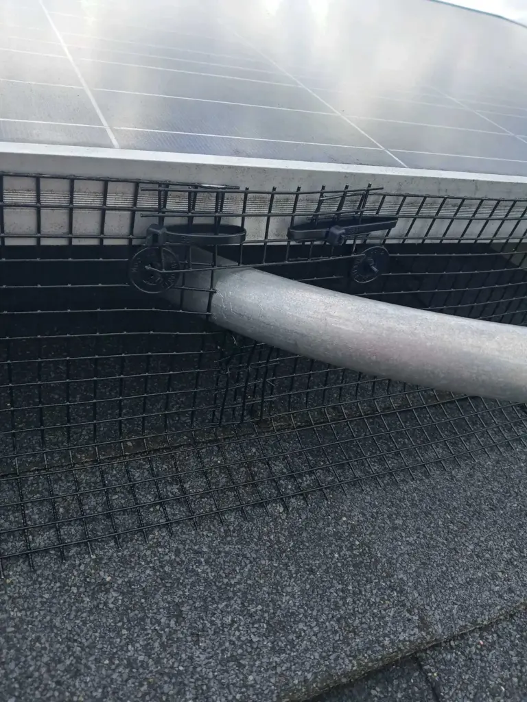 Close-up of solar panel critter guard mesh installed to block bird nesting